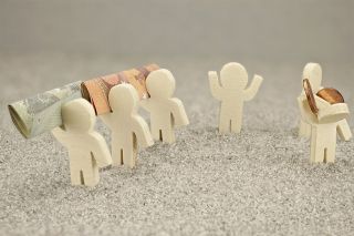 Foto: Kleine Figuren mit Geldscheinen und Münzen